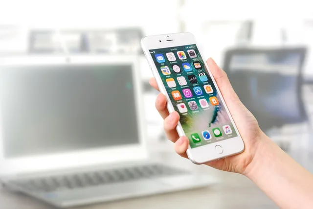 woman holding a smartphone, technology, equipment, apple, iphone, cell, telephone, smartphone, plus, screen, office, work, work station, app, workplace, business, laptop, software, businessman, notebook, write, corporation, work desk, modern, white, marketing, profi, background blurred, internet, management, communication, computers, touchscreen, chairs, hand female, icons, ios, app, software, software, software, software, software, ios. Scegliere un ERP per una PMI svizzera: requisiti, conformità e fasi